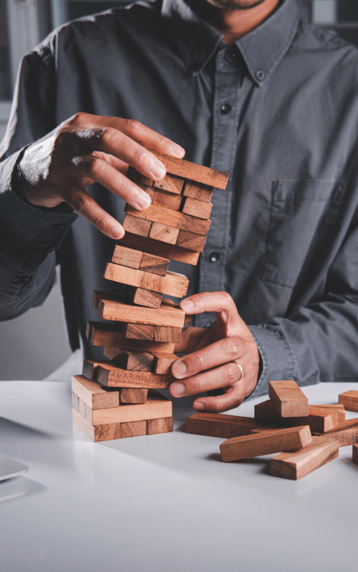 An executive saving a tumbling tower of blocks representing his marketing strategy